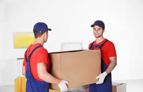 Furniture removal team handling items in a Queens Park home