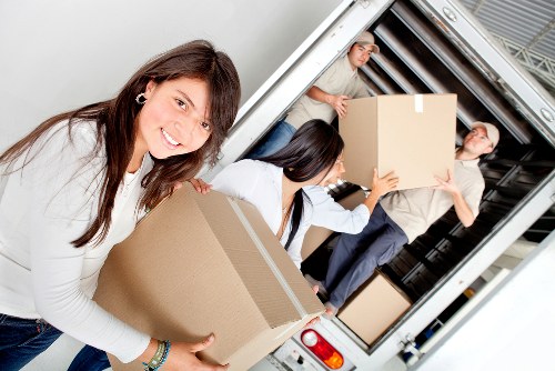 Business relocation service handling packed boxes and desks in Queens Park