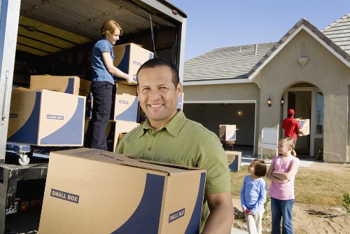 Packed moving boxes and furniture loading for a house move in Queens Park